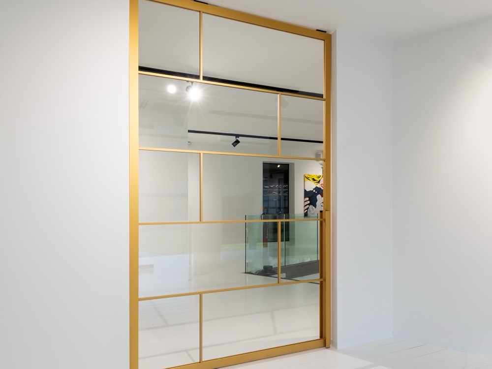 Gold Anodized — Lightfall glass pivot door by Serene Glass, Houston TX